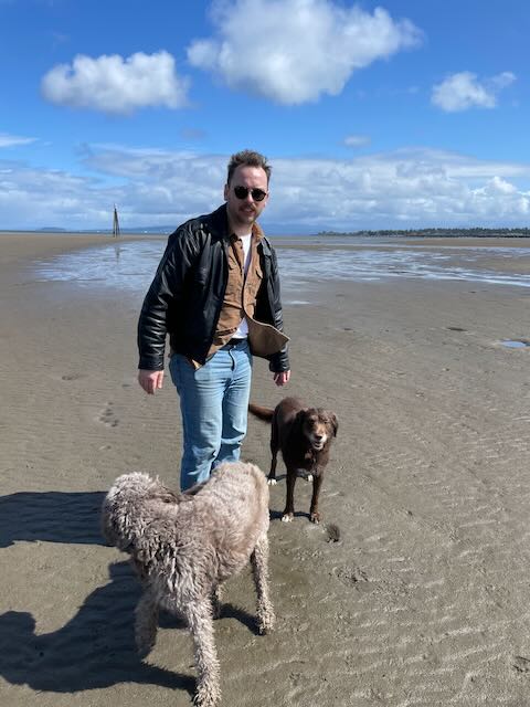 Me, Josh Dean, and my dogs, on a beach, it's windy, and we look pretty silly.